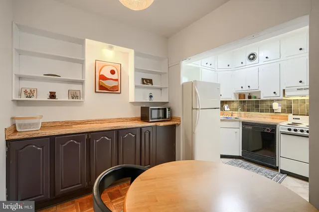 a kitchen with stainless steel appliances granite countertop a refrigerator a stove a sink and a microwave