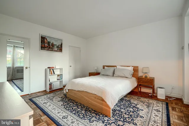 a bedroom with a bed rug and wooden floor