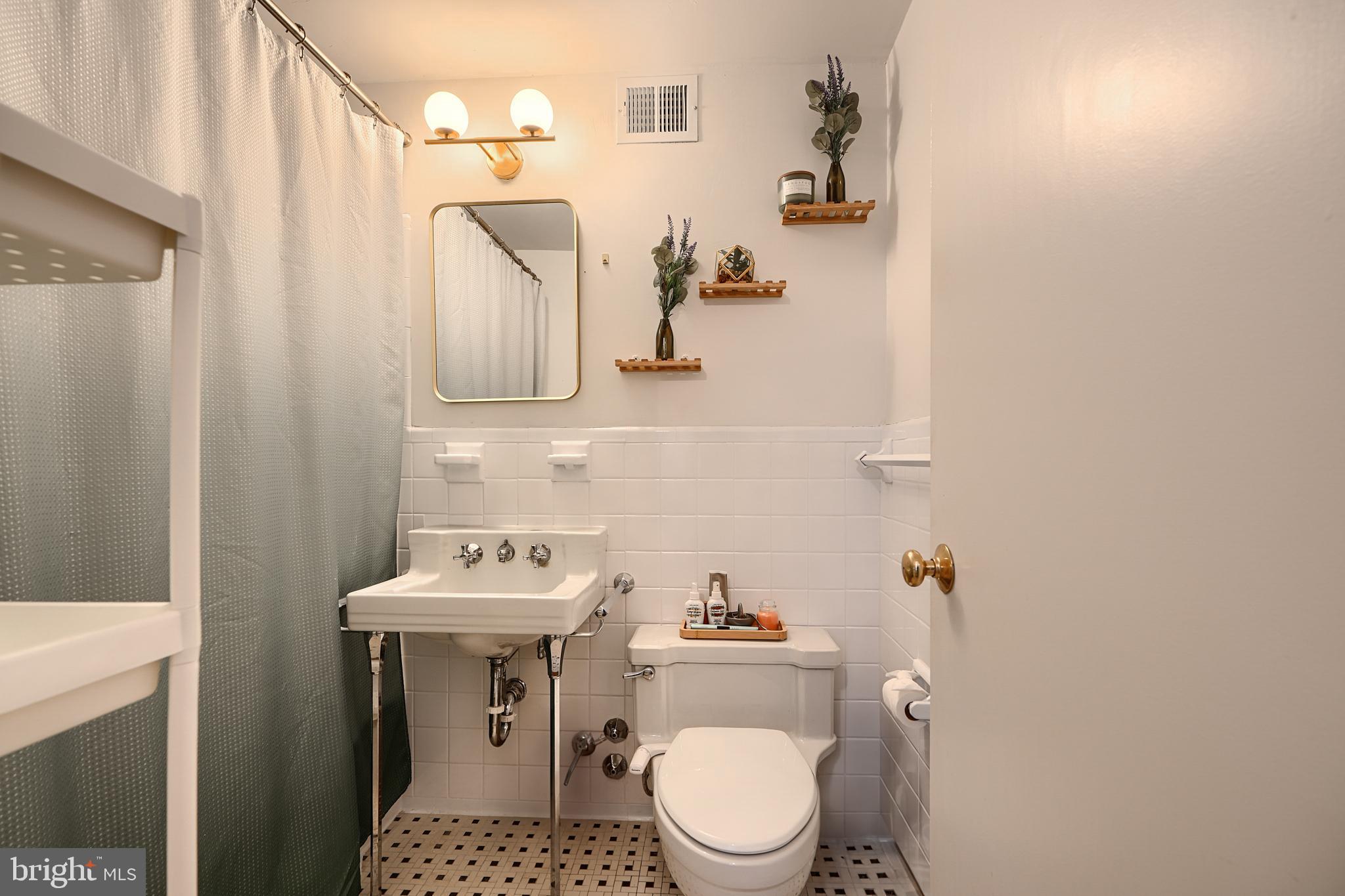 3601 Greenway, Unit 303 Baltimore, MD 21218 - Photo 19 of 30 a bathroom with a sink toilet and mirror