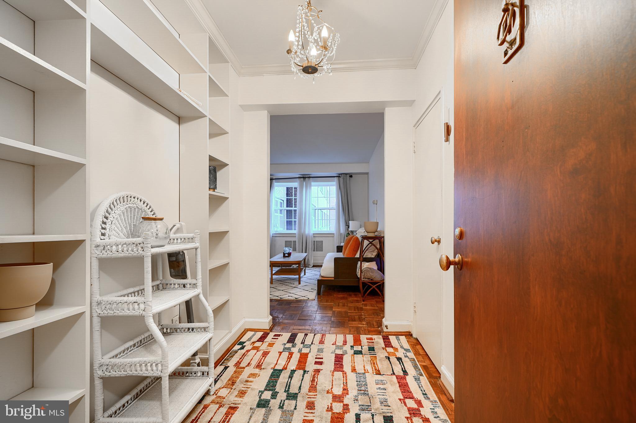 3601 Greenway, Unit 303 Baltimore, MD 21218 - Photo 2 of 30 a living room with a couch and a chandelier