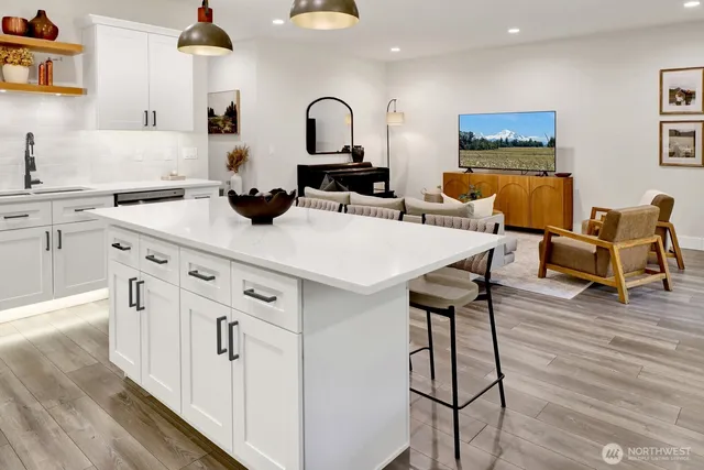 a kitchen with stainless steel appliances a stove a sink a refrigerator and wooden floor