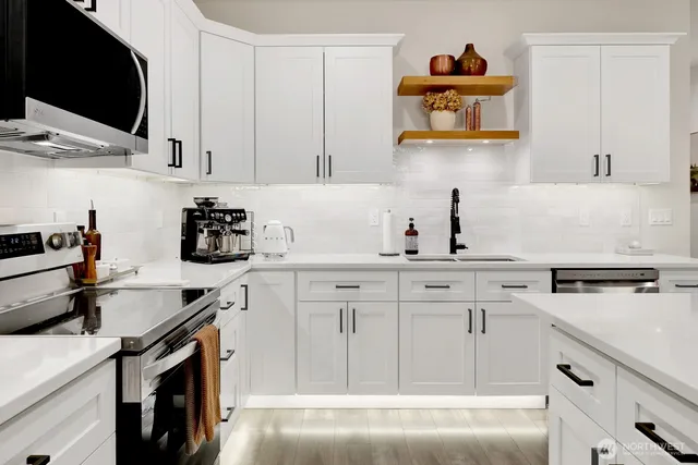 a kitchen with white cabinets and sink