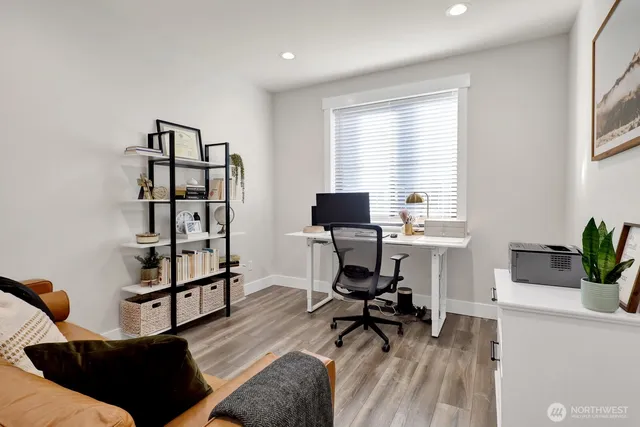 a view of a workspace with furniture and a window