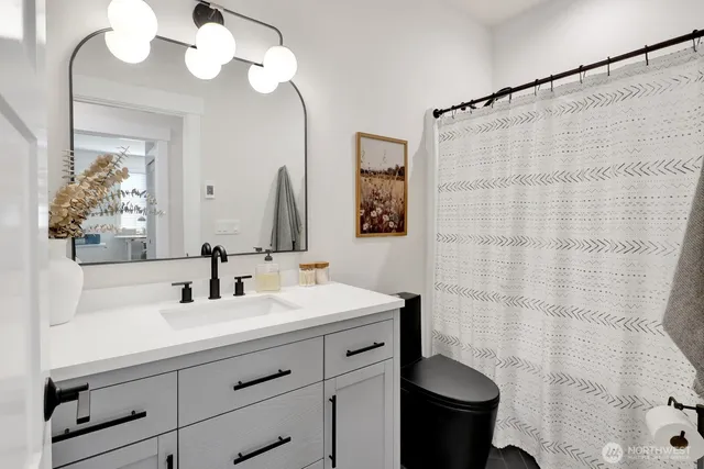 a bathroom with a sink a toilet and a mirror