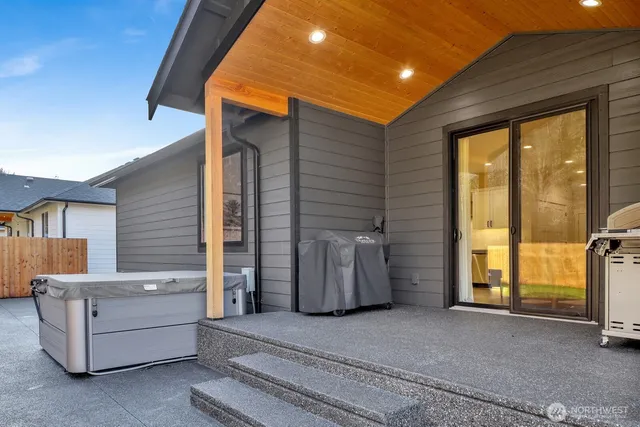 a view of a patio with table and chairs and a barbeque