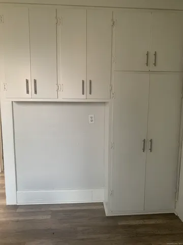 a view of a kitchen with refrigerator and white cabinets
