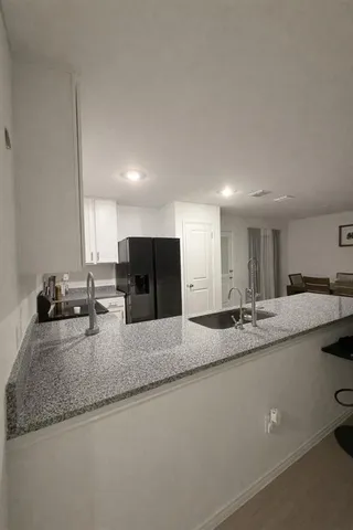 a kitchen with stainless steel appliances granite countertop a sink a stove and a refrigerator