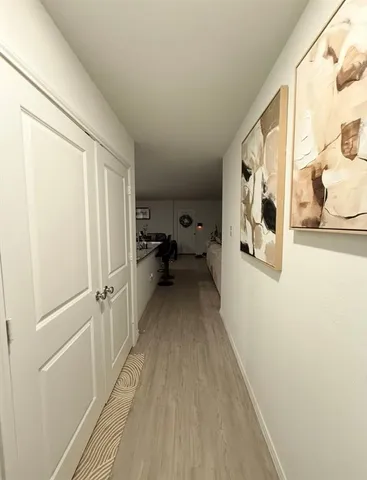 a view of a hallway with wooden floor and furniture