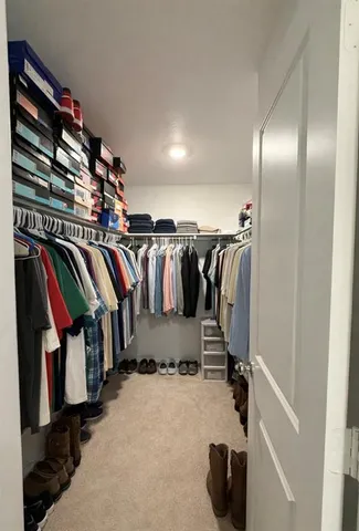 a view of walk in closet with clothes and shoes