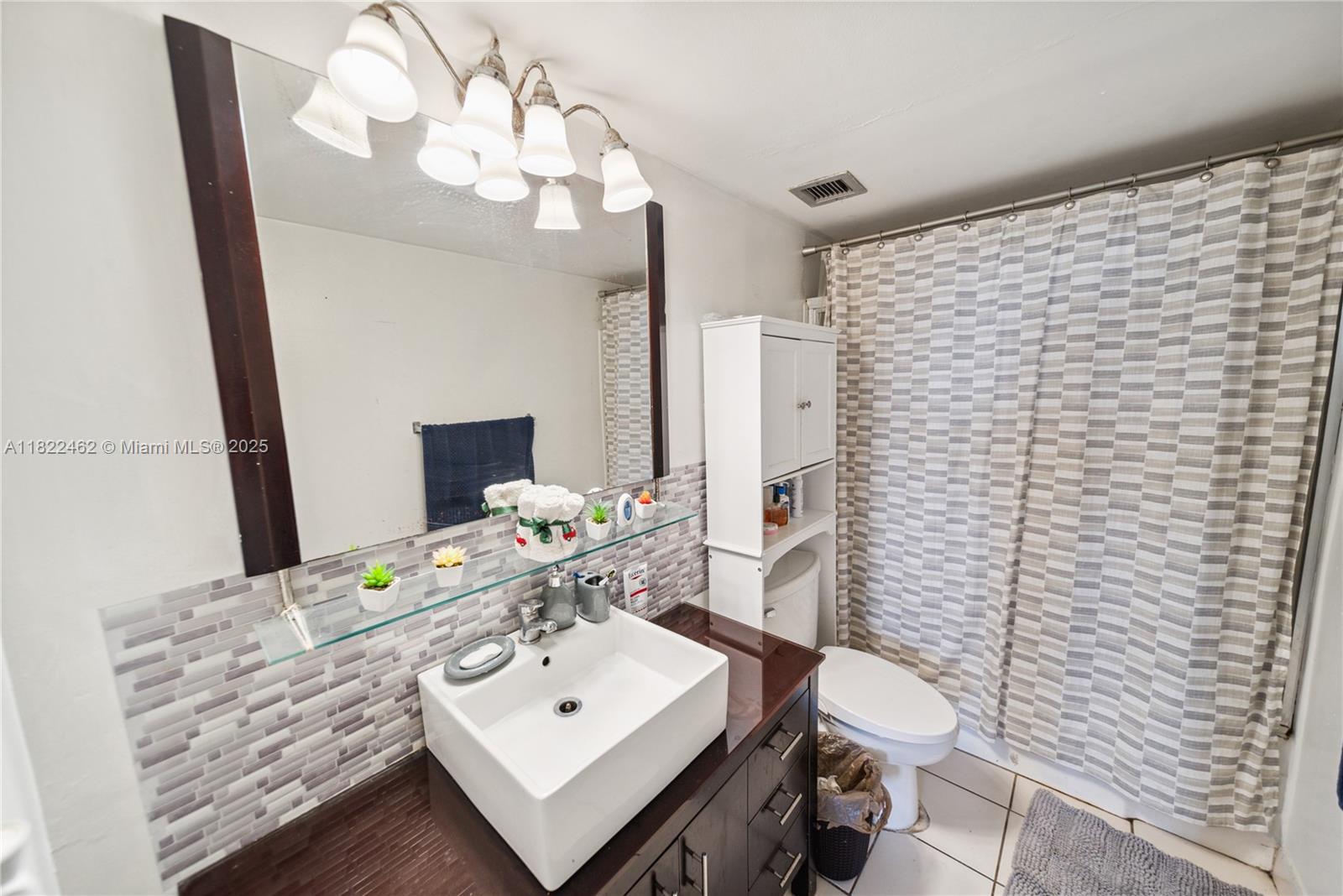 13499 Biscayne Boulevard, Unit 703 North Miami, FL 33181 - Photo 11 of 38 a bathroom with a sink a toilet and mirror