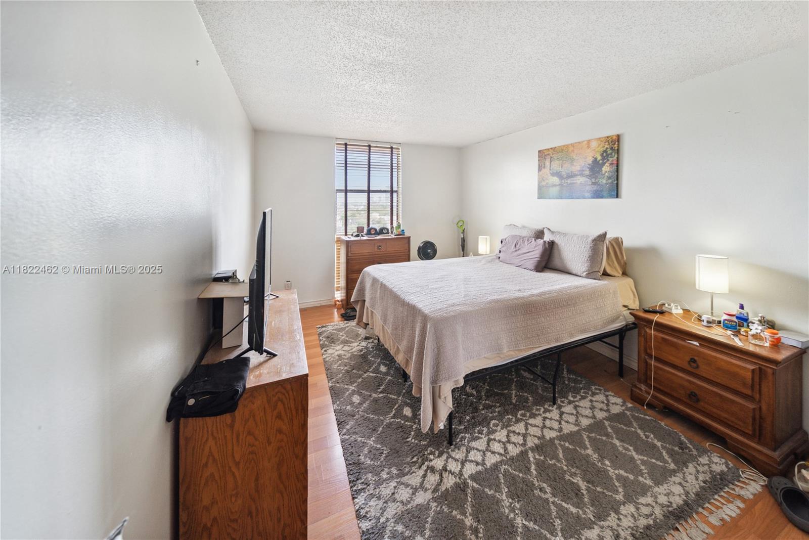 13499 Biscayne Boulevard, Unit 703 North Miami, FL 33181 - Photo 12 of 38 a bedroom with a bed and wooden floor