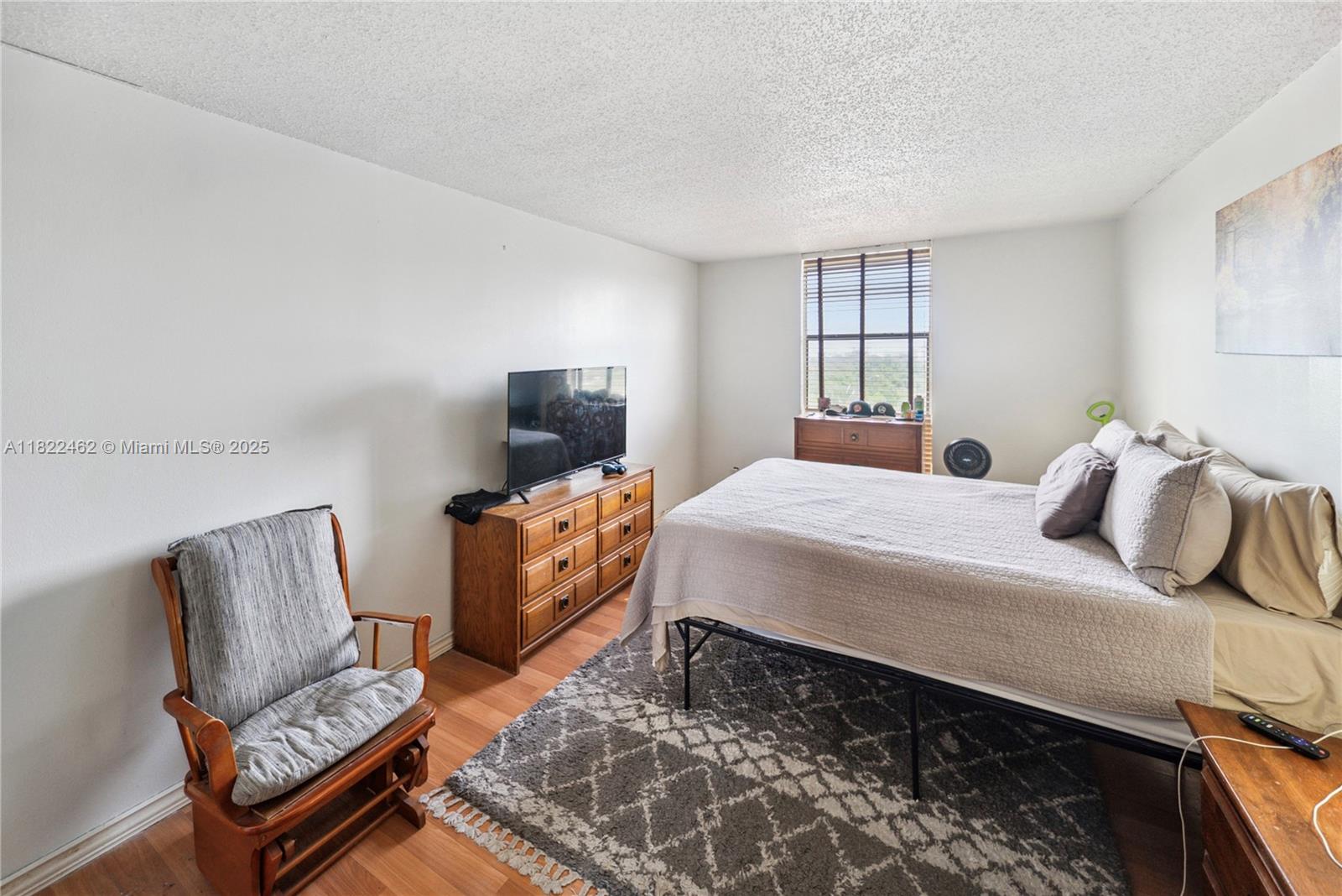 13499 Biscayne Boulevard, Unit 703 North Miami, FL 33181 - Photo 13 of 38 a bedroom with a bed and wooden floor