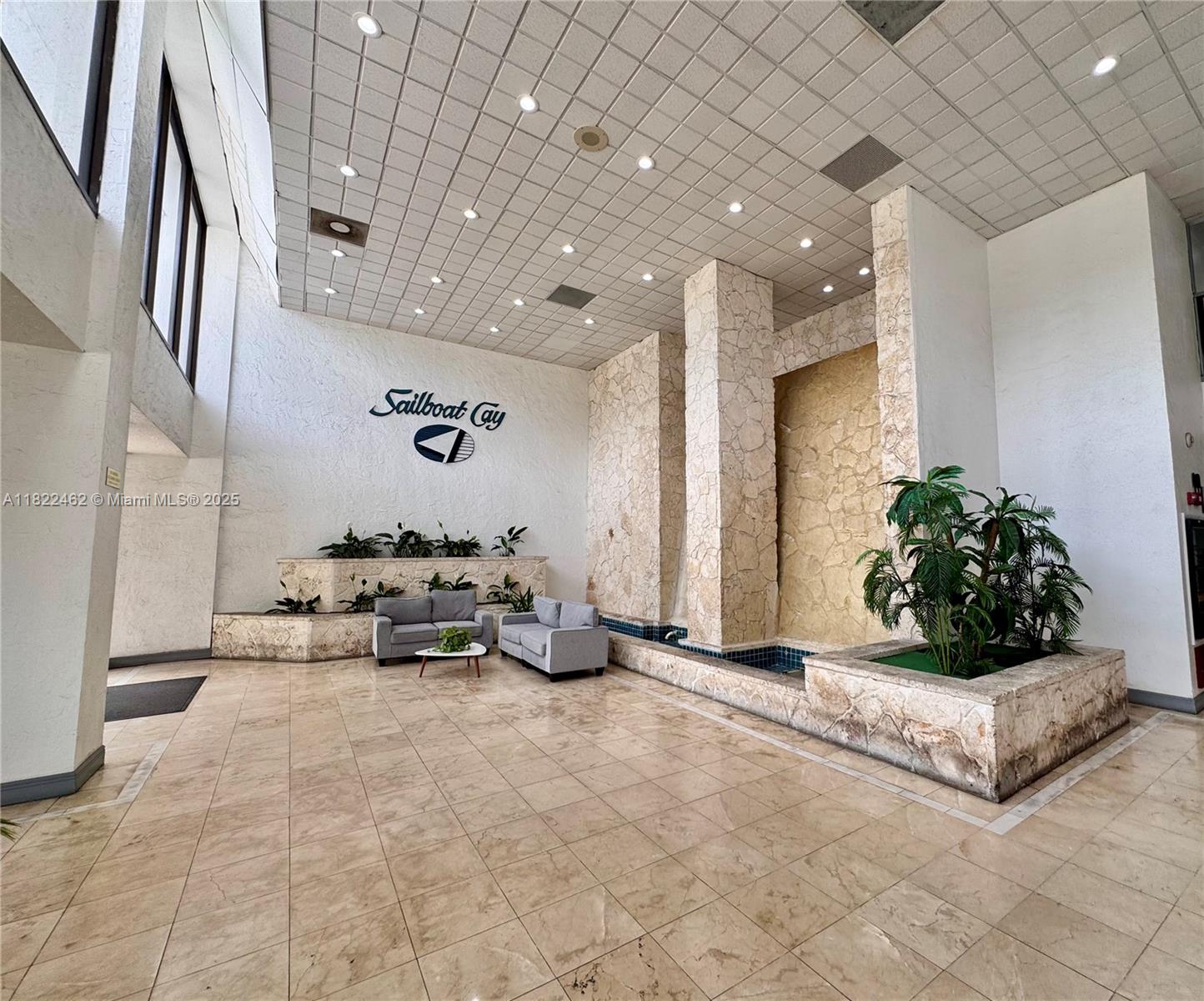 13499 Biscayne Boulevard, Unit 703 North Miami, FL 33181 - Photo 19 of 38 a living room with furniture and a chandelier