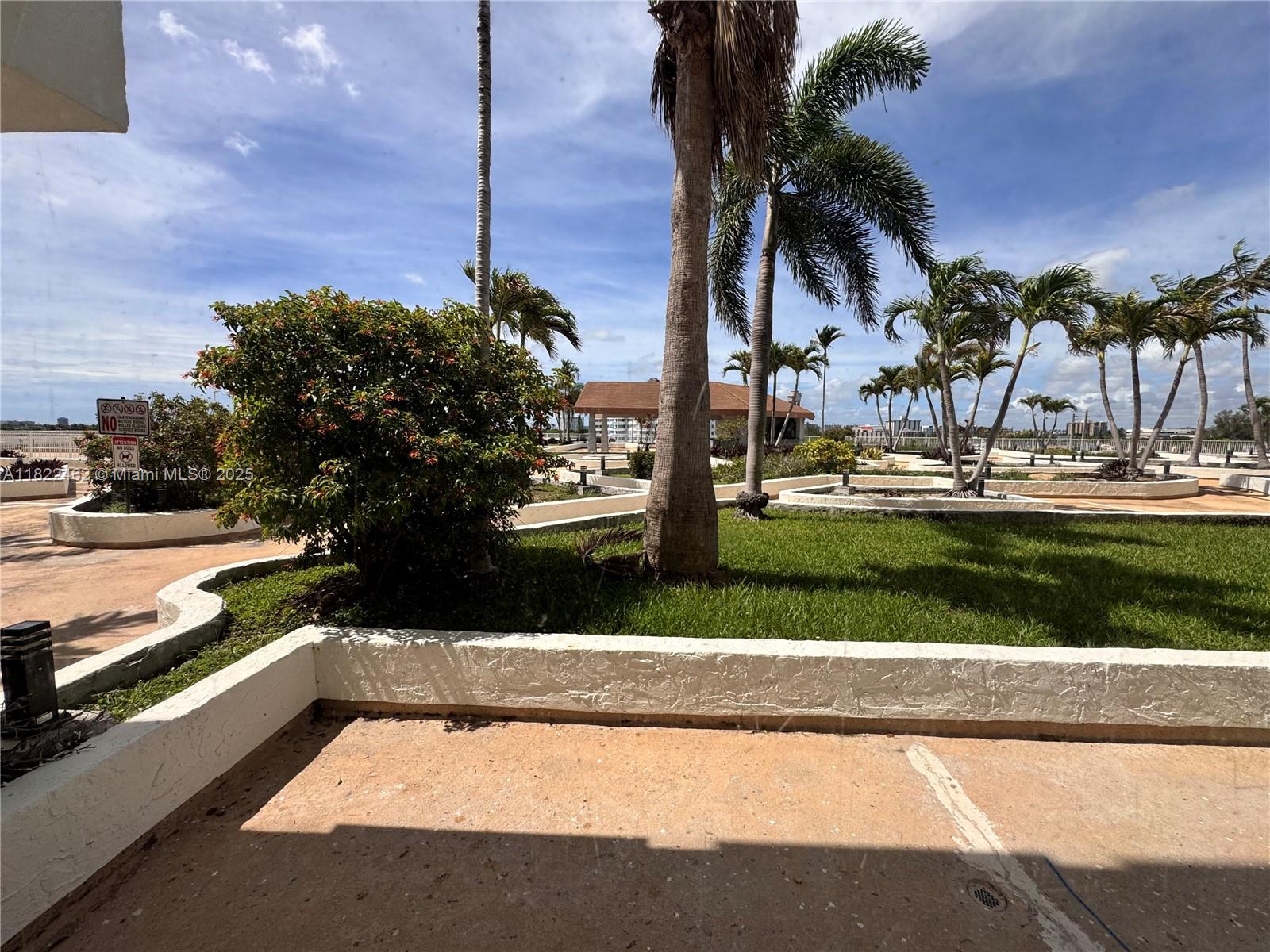 13499 Biscayne Boulevard, Unit 703 North Miami, FL 33181 - Photo 22 of 38 a view of a yard and palm trees