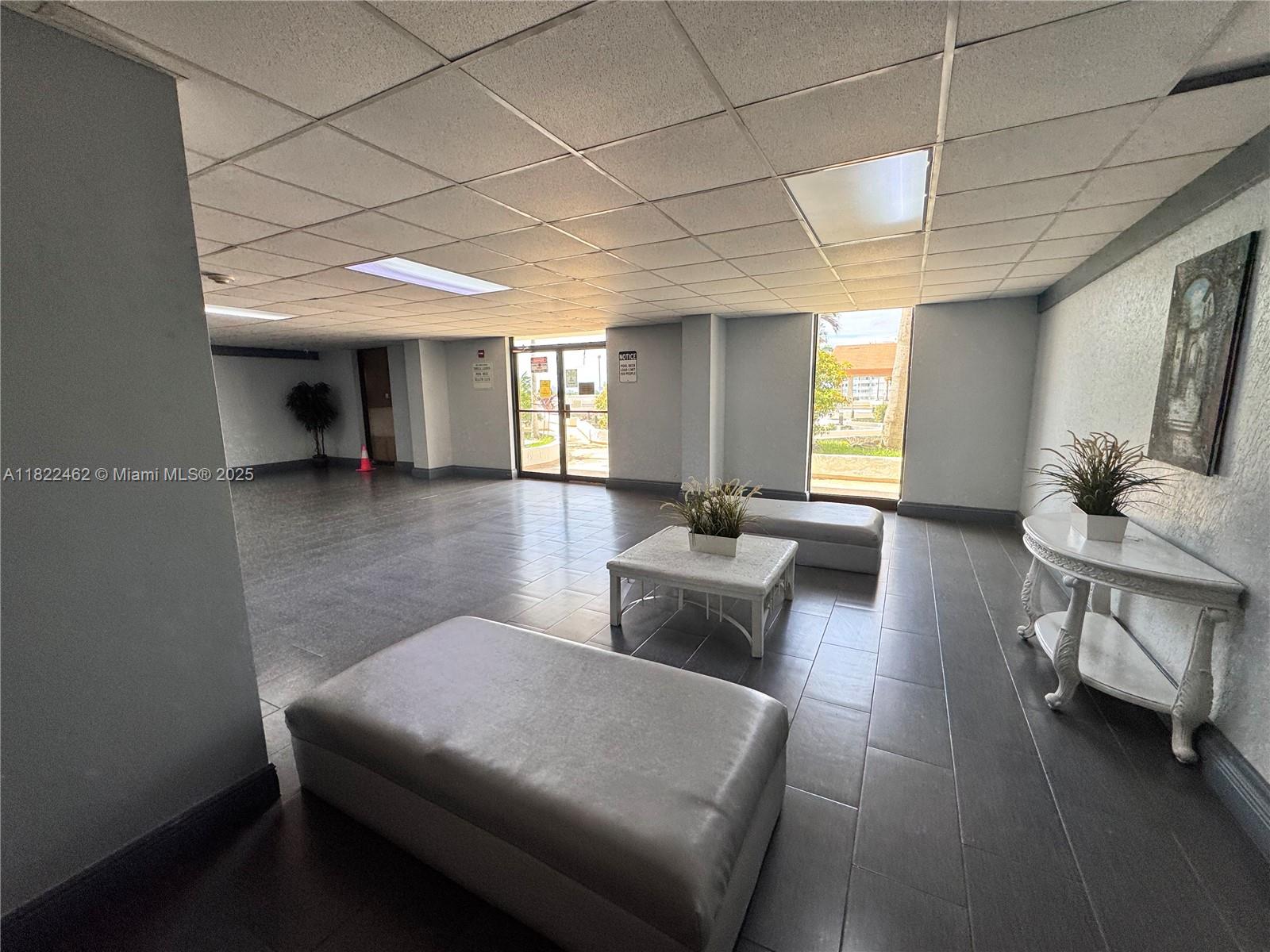13499 Biscayne Boulevard, Unit 703 North Miami, FL 33181 - Photo 23 of 38 a living room with furniture and a chandelier