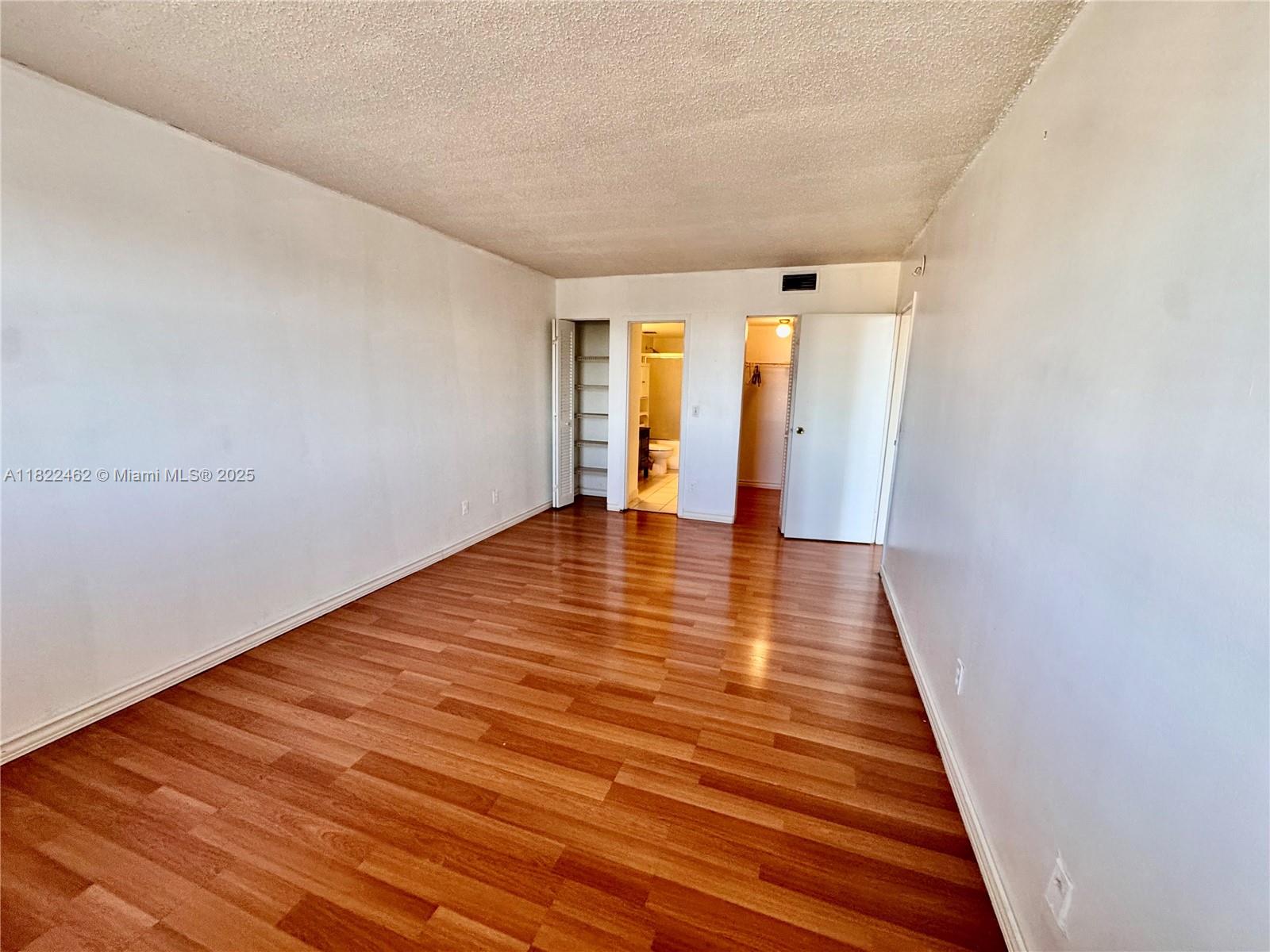 13499 Biscayne Boulevard, Unit 703 North Miami, FL 33181 - Photo 28 of 38 a view of an empty room with wooden floor and a window