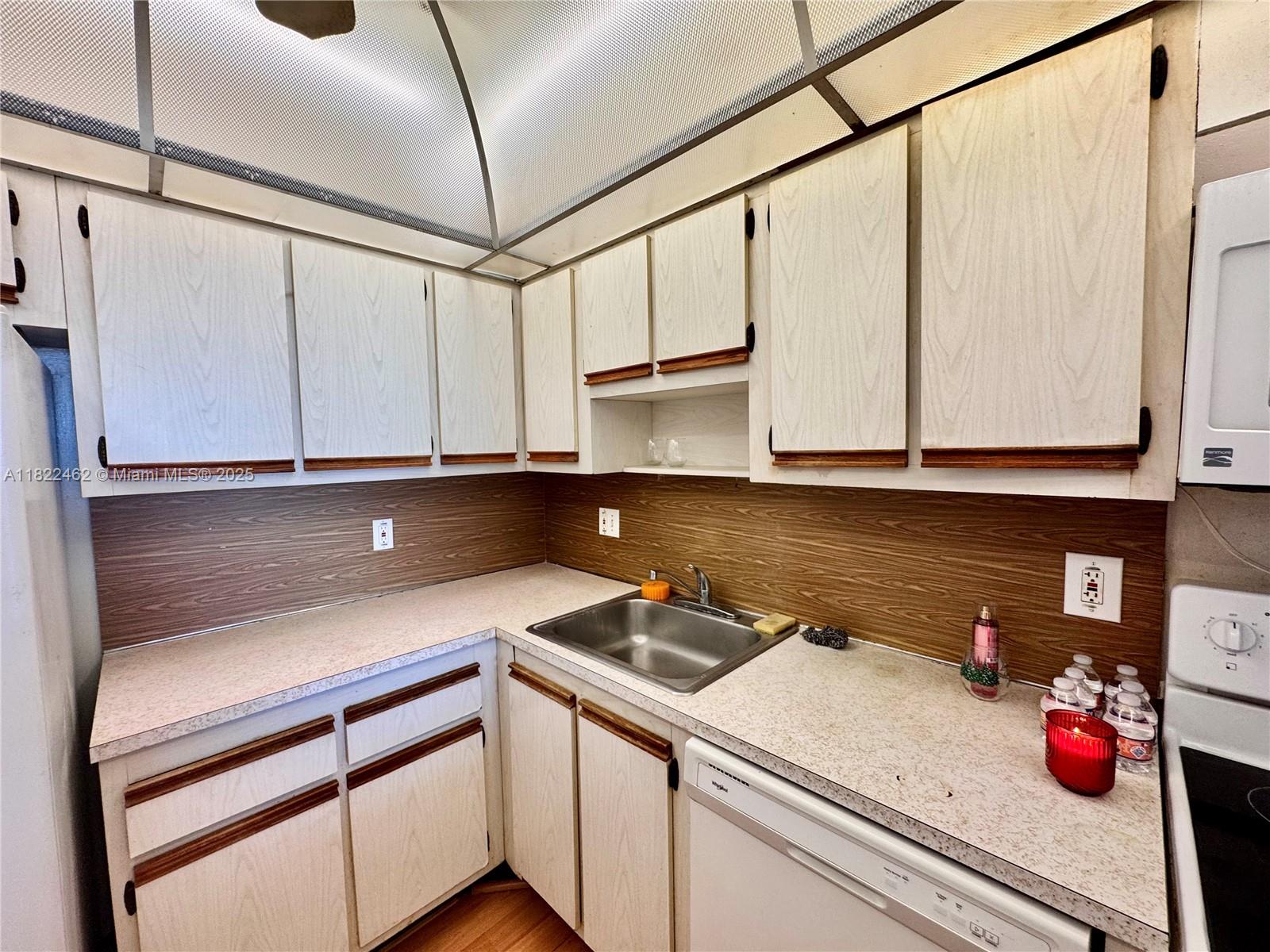13499 Biscayne Boulevard, Unit 703 North Miami, FL 33181 - Photo 34 of 38 a kitchen with a sink cabinets and appliances
