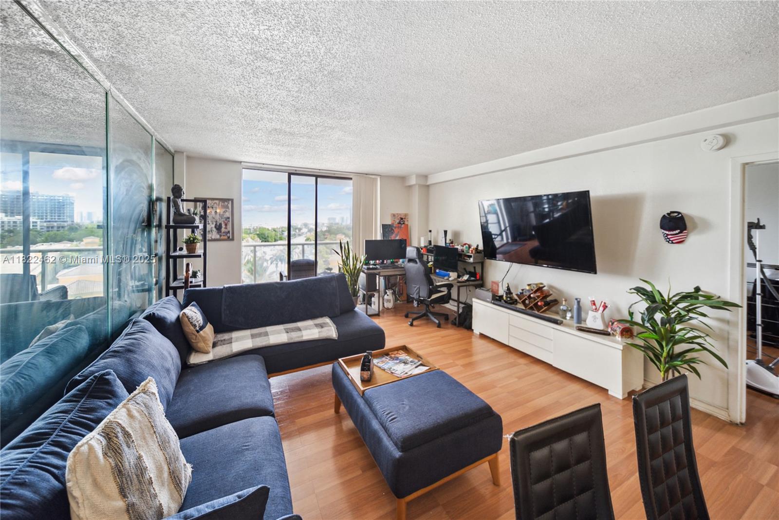 13499 Biscayne Boulevard, Unit 703 North Miami, FL 33181 - Photo 6 of 38 a living room with furniture and a flat screen tv