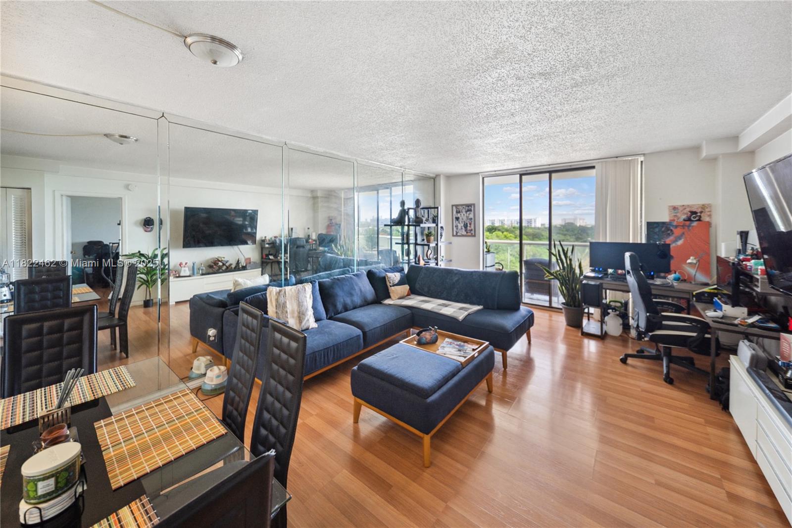 13499 Biscayne Boulevard, Unit 703 North Miami, FL 33181 - Photo 7 of 38 a living room with furniture wooden floor and a flat screen tv