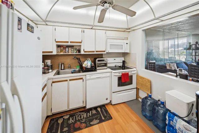 a kitchen with a refrigerator and white cabinets