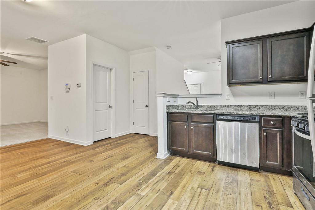 7365 St Peter Way Fairburn, GA 30213 - Photo 7 of 19 a kitchen with granite countertop a sink cabinets and wooden floor