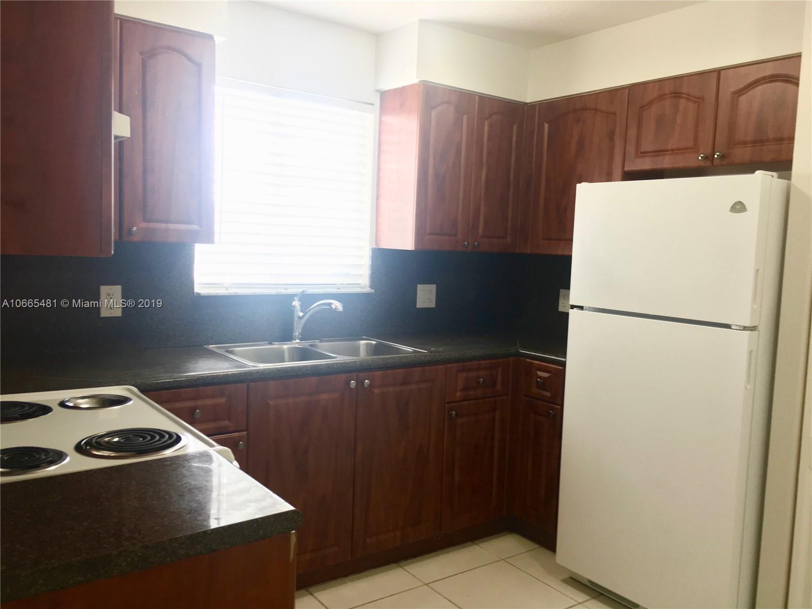 1453 Southwest 3rd Street, Unit 305 Miami, FL 33135 - Photo 4 of 12 a kitchen with a refrigerator and a sink