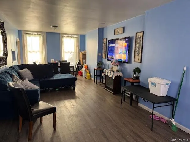 a living room with furniture a flat screen tv and a window