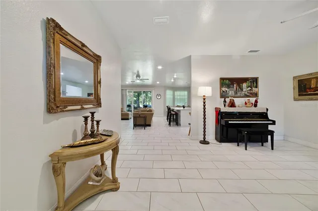 a living room with furniture a piano and a flat screen tv