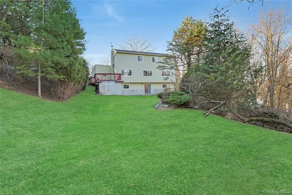 a view of backyard with table and chairs and potted plants and large trees