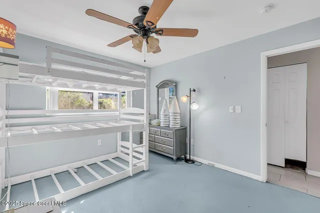 an empty room with closet and a ceiling fan
