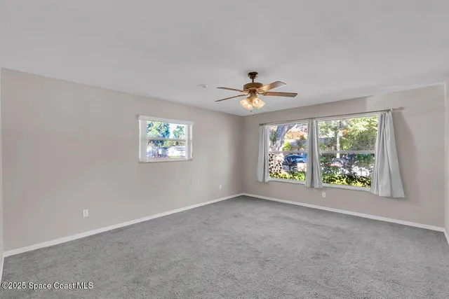 a view of a room with a ceiling fan and window