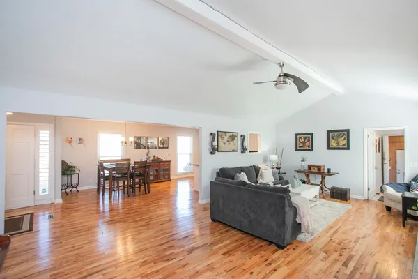 a living room with furniture and a wooden floor