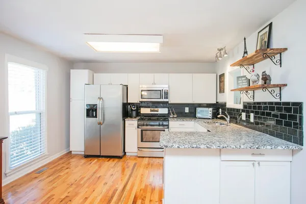 a kitchen with stainless steel appliances granite countertop a stove a sink and a refrigerator