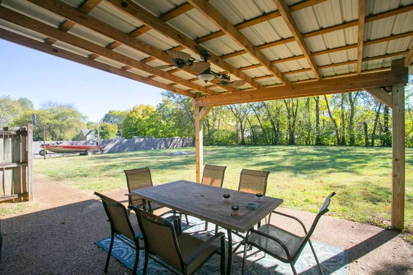 a view of a lake with a table chairs and a swimming pool