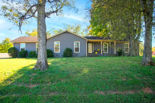 a view of a house with a yard and potted plants