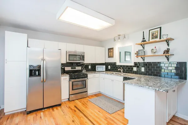 a kitchen with stainless steel appliances granite countertop a refrigerator and a stove
