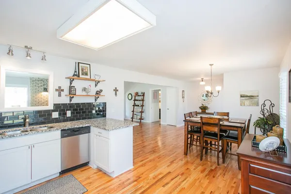 a large kitchen with cabinets wooden floor and stainless steel appliances