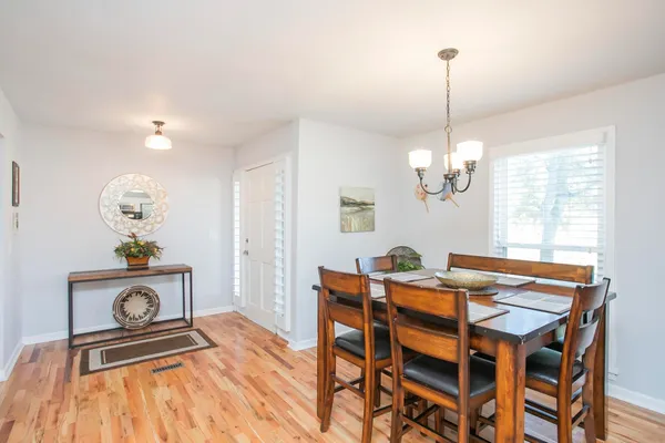 a view of a dining room with furniture a chandelier and wooden floor