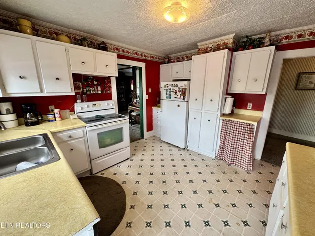 a bedroom with a bed and dresser with wooden floor