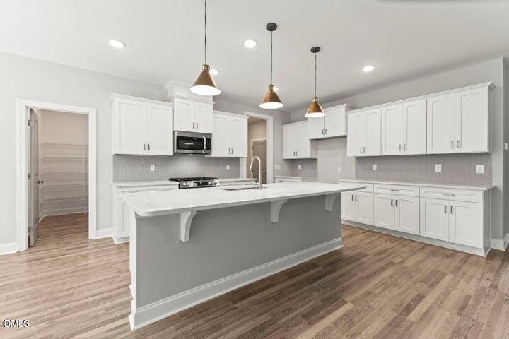 25 West Victoria Rdg Drive, Unit 15 Selma, NC 27576 - Photo 8 of 35 a large kitchen with stainless steel appliances granite countertop a stove a sink and white cabinets