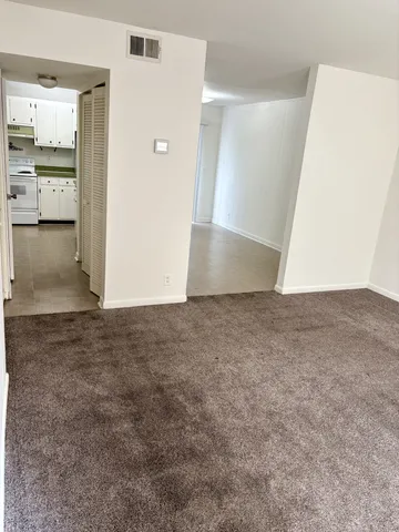 an empty room with kitchen and a sink