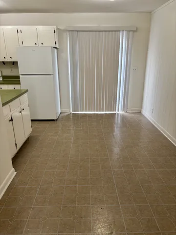 a view of a kitchen with white cabinets and white appliances