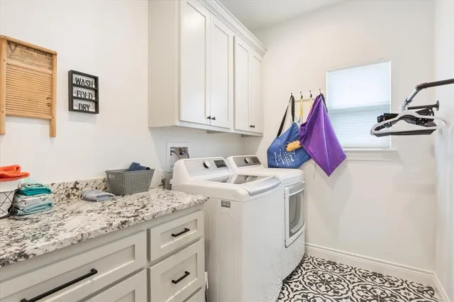 a kitchen with a sink dishwasher and white cabinets