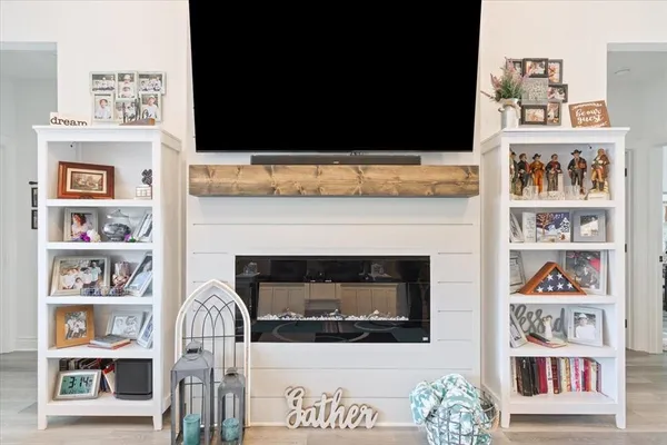 a living room with a fireplace and a book shelf