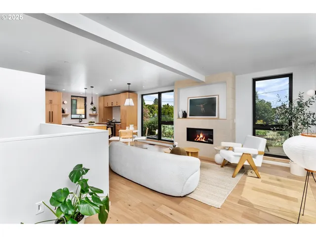 a living room with fireplace furniture and a large window
