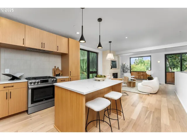 a large kitchen with kitchen island a stove a sink a center island and cabinets