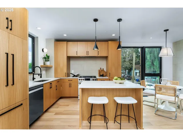 a kitchen with kitchen island a stove a refrigerator a sink dishwasher a oven with a dining table and chairs