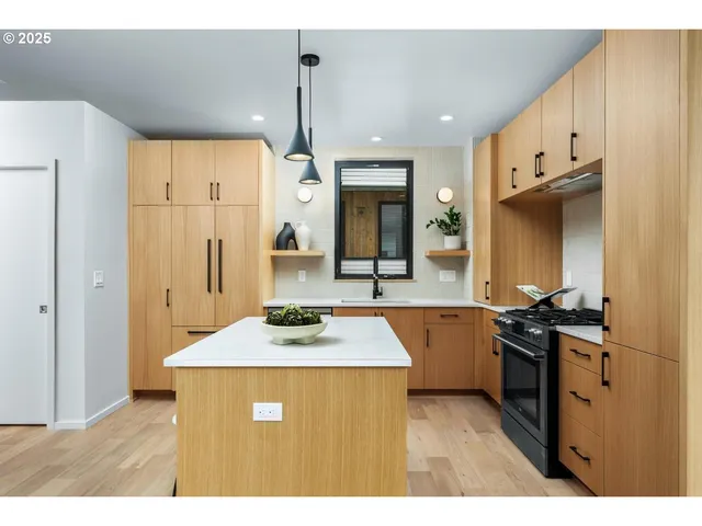a kitchen with stainless steel appliances granite countertop a sink a stove and a refrigerator