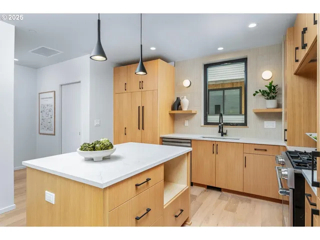 a kitchen with a sink a counter space and wooden floor