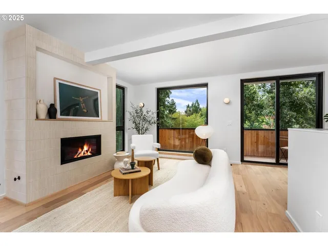 a living room with furniture a fireplace and a floor to ceiling window